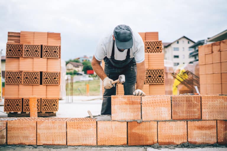 Close up details of industrial bricklayer installing bricks on construction site"n