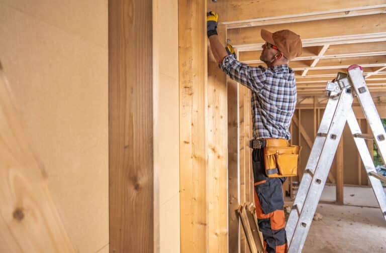 House Construction Supervisor Checking on Wooden Beam